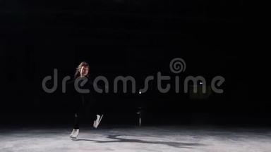 一名职业<strong>花样滑冰</strong>运动员穿着黑色西装，在空中跳跃，以黑色背景表演<strong>滑冰</strong>。冰